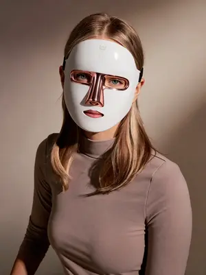 Studio portrait of a woman wearing the Lumoras LED face mask
